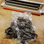 Beef jerky in a vacuum sealed package on a table with a vacuum sealer