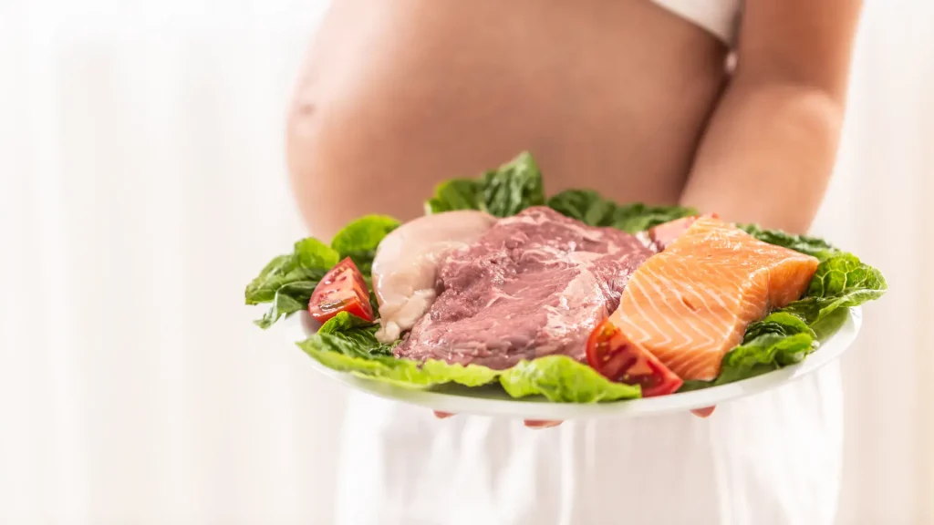 A pregnant woman holding a plate of raw meat and seafood while wondering to herself, can you eat beef jerky while pregnant?