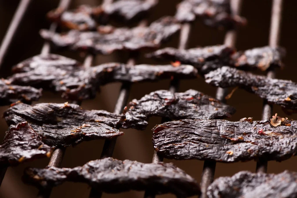 Homemade beef jerky dehydrating on wire racks