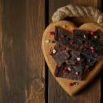 A wooden heart with beef jerky illustrating an answer to the question "is beef jerky healthy?"